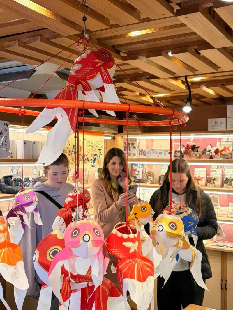 Guests browsing traditional goldfish lanterns at an Asakusa shop