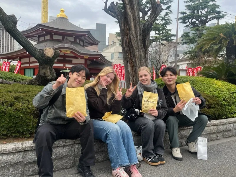Guests enjoying local sweets near a temple in Asakusa